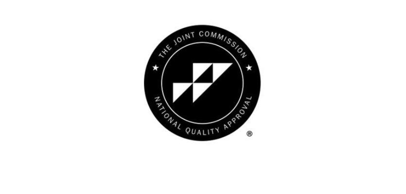 A black circular seal with the text The Joint Commission National Quality Approval surrounds a geometric logo in the center, highlighting its LP-SIMPLE-IOP certification.